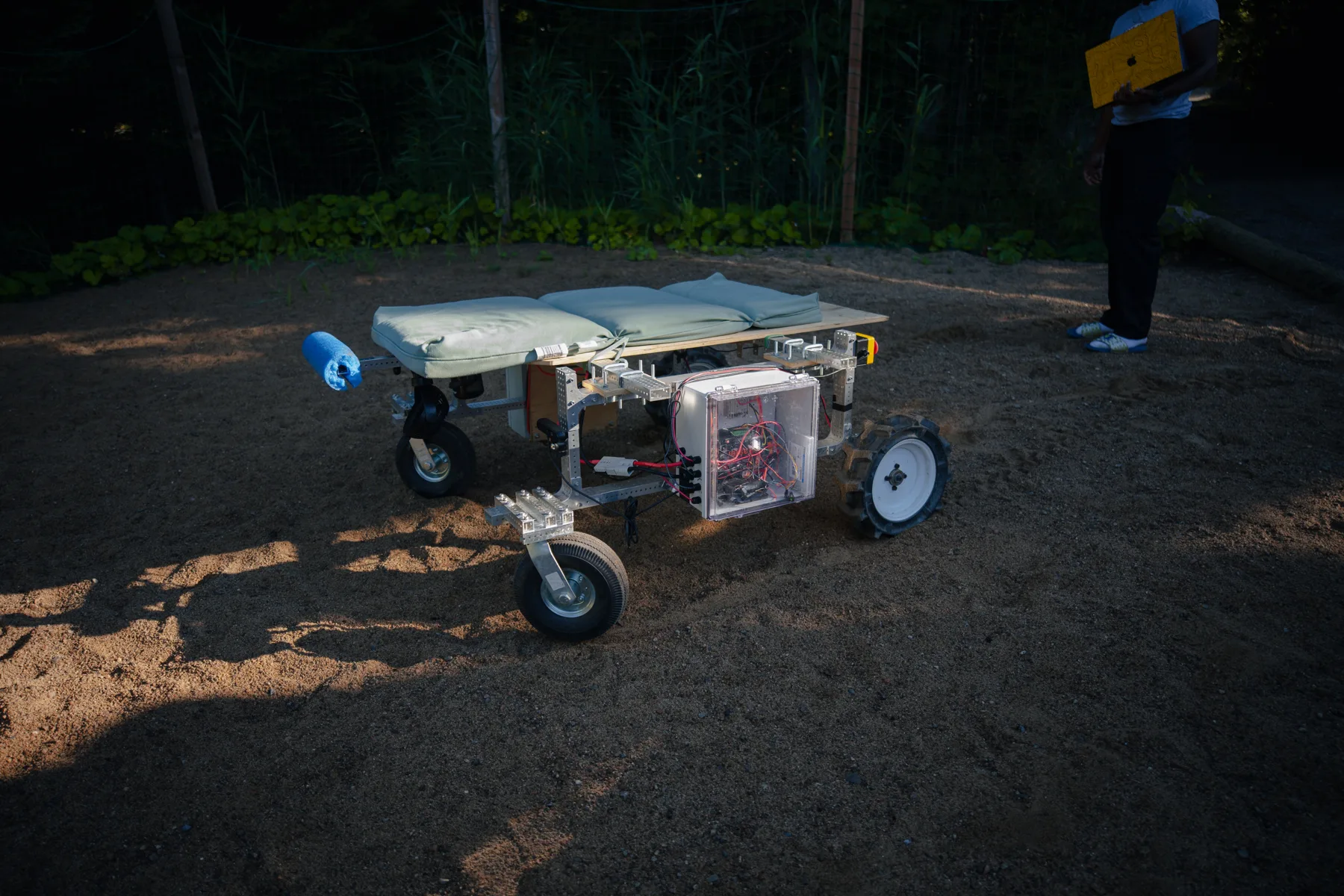 A Tandem Robotics farm robot parked on gravel outside the chalet