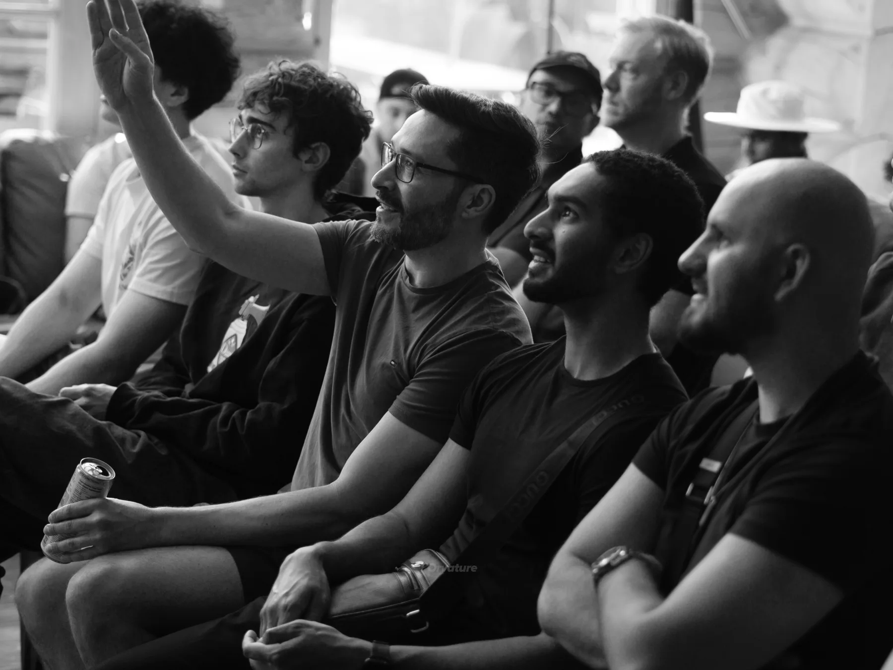 Black and white photo of the audience during the demos, one person raising a hand